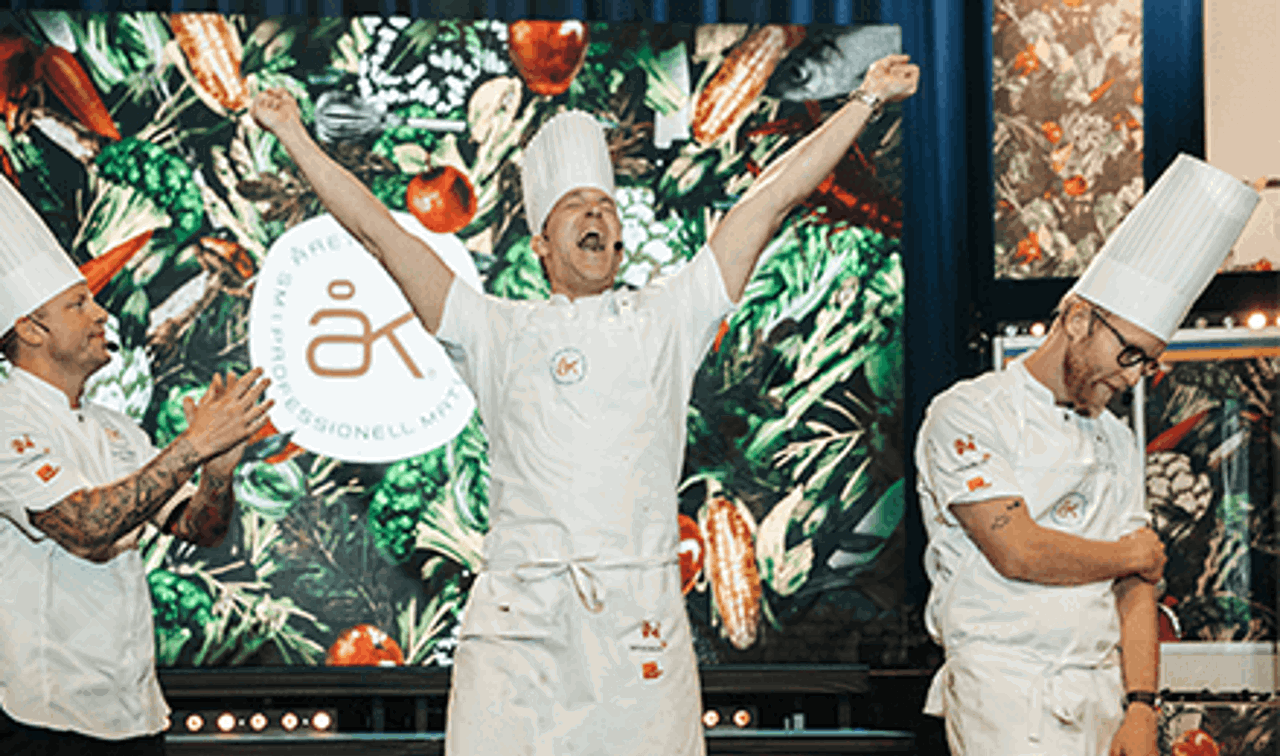 En glad vinnare av Årets Kock höjer sina armar i luften av lycka