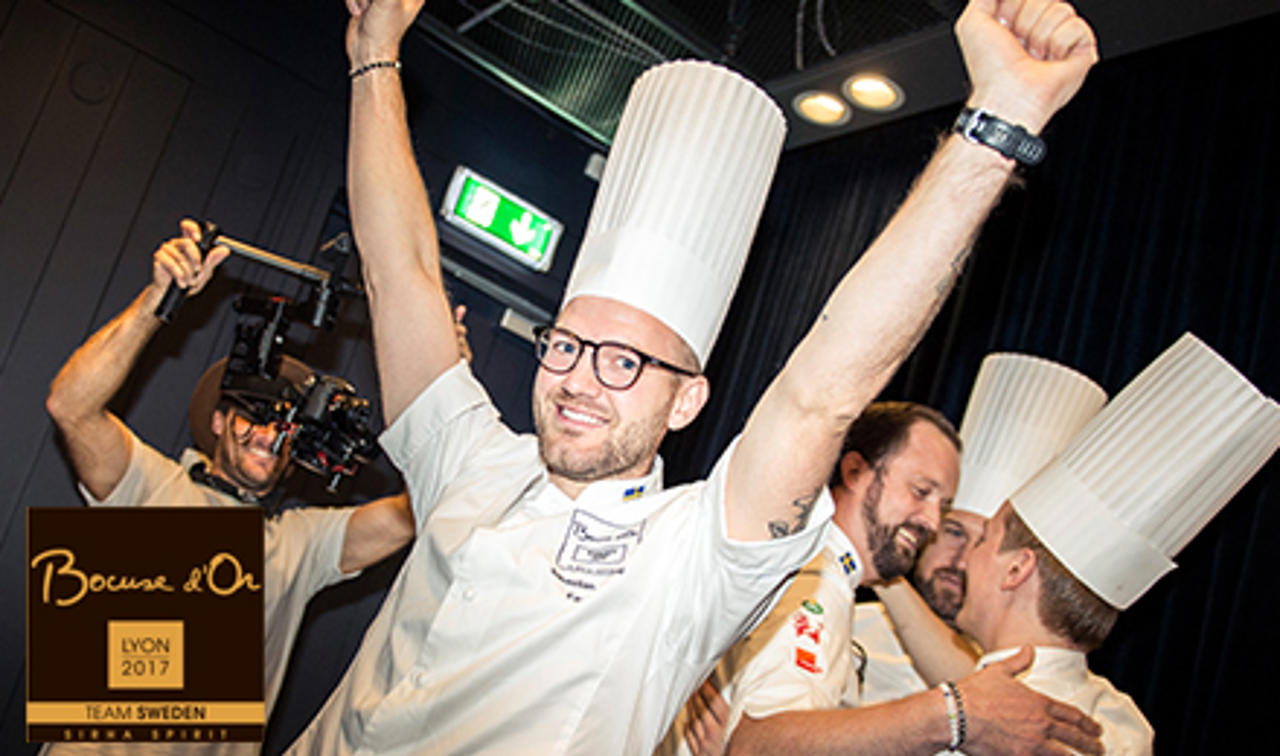En glad Sebastian Gibrand, vinnare av Bocuse d'or 2017, höjer sina händerna i luften av lycka